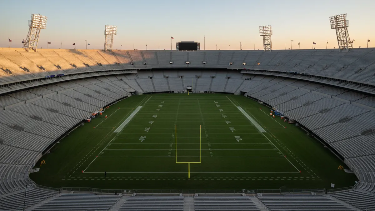 Vista amplia del estadio de la NFL al atardecer, campo vacío.